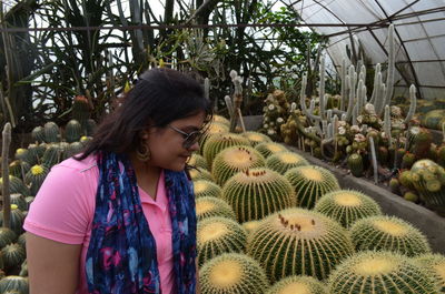 Mid adult woman standing in greenhouse