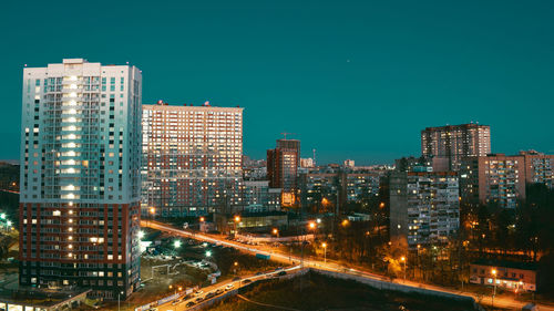 Illuminated buildings in city against sky at night