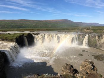 Scenic view of waterfall against sky