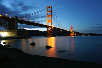 Low angle view of illuminated bridge over sea against sky