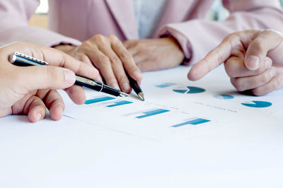 Close-up of man holding hands on table