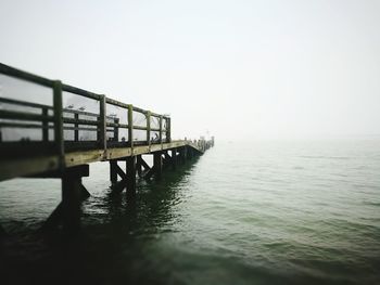 Bridge over sea against clear sky