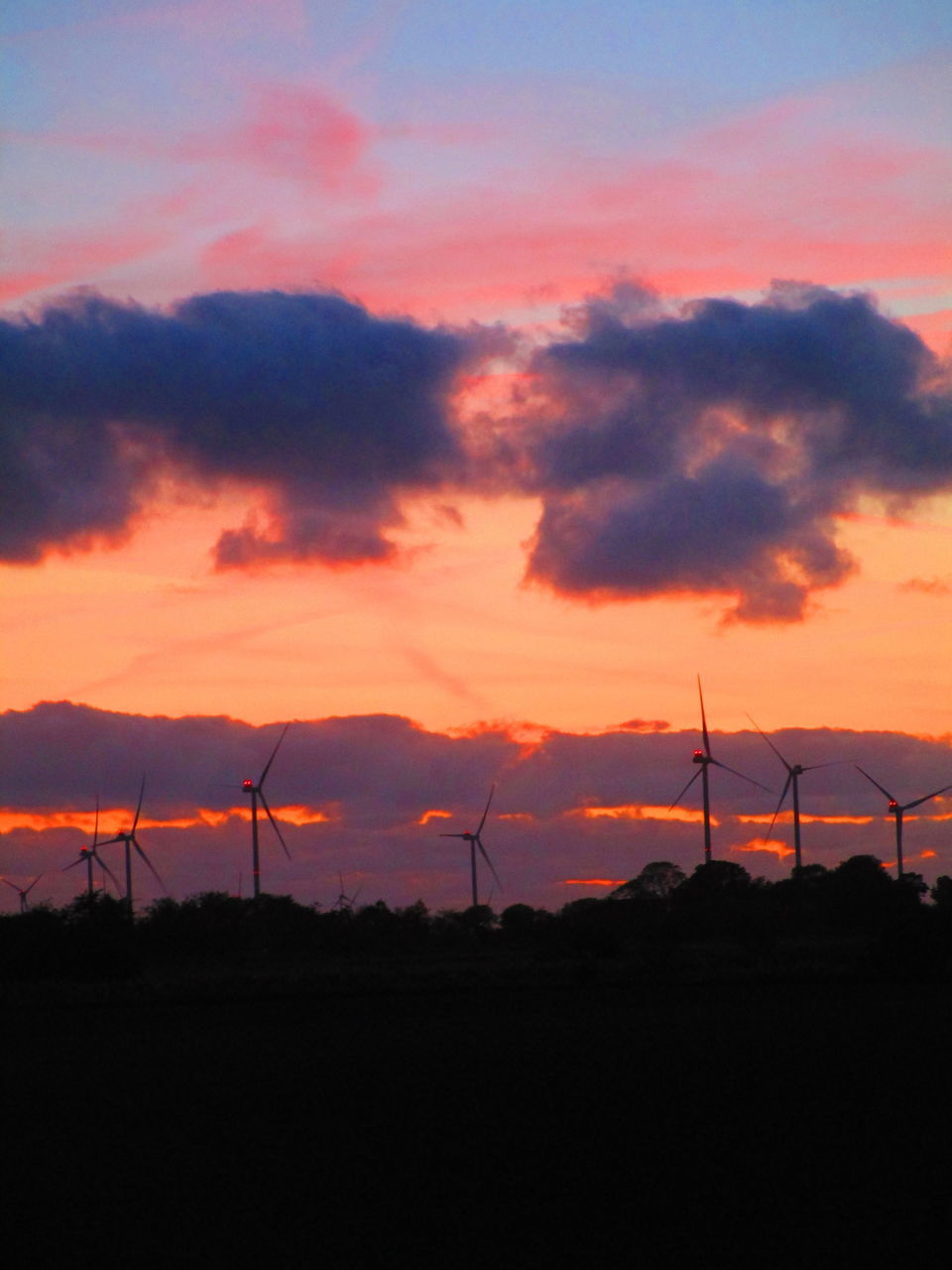 SILHOUETTE WIND TURBINES ON FIELD AGAINST SKY AT SUNSET