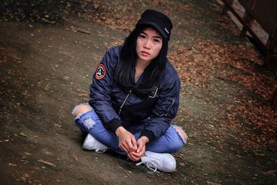 Portrait of young woman sitting on field