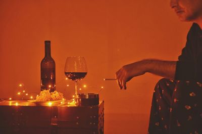 Man smoking against orange wall