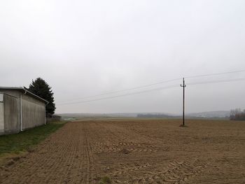 Electricity pylon on field against sky