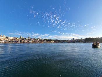 City at waterfront against blue sky