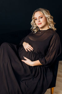 Portrait of beautiful woman against black background