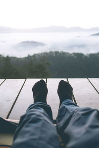 Low section of man standing against sky