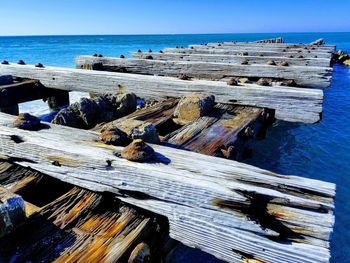 Stack of rocks on beach against clear blue sky