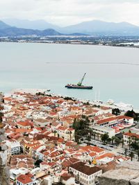 High angle view of townscape by sea against sky