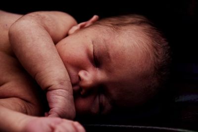 Close-up of baby sleeping on bed