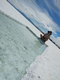 High angle view of shirtless man in sea against sky