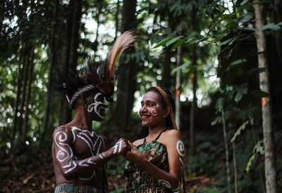 Woman standing by plants in forest