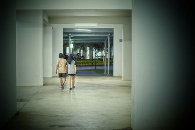 Rear view of woman walking in corridor of building