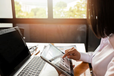 Midsection of woman using laptop at office
