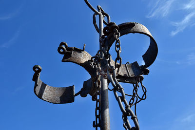 Low angle view of metal against blue sky