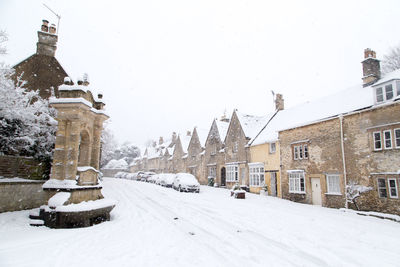 Snow covered buildings against sky