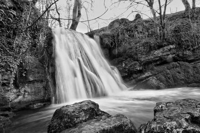 Low angle view of waterfall against sky