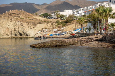 Scenic view of river against buildings and mountains