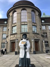 Portrait of man standing against building in city