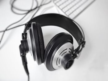 High angle view of headphones and computer keyboard on white background