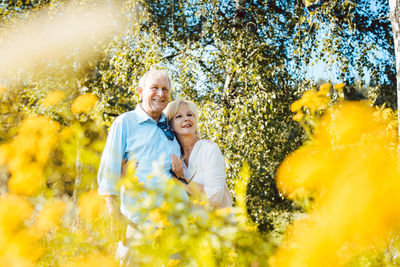 Portrait of a smiling young man on yellow flowering plants