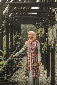 Full length of woman standing by railing