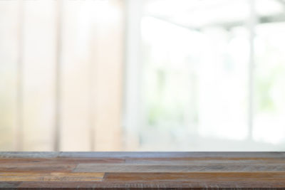 Close-up of wooden table against wall at home