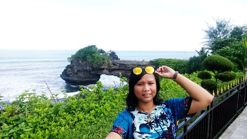 Portrait of woman standing against sea against clear sky