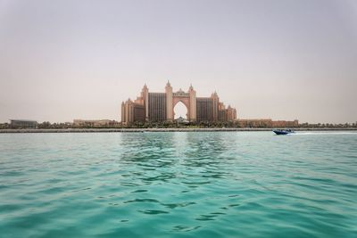 View of buildings by sea against clear sky