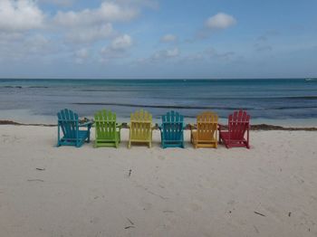 Adirondack chairs on shore at beach