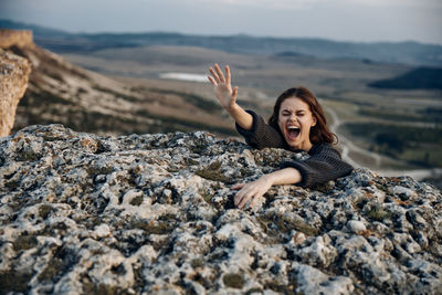 Young woman sitting on rock