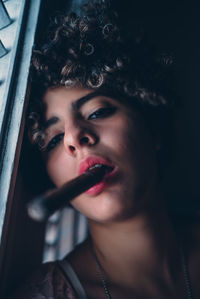 Close-up of young woman smoking a sigar 