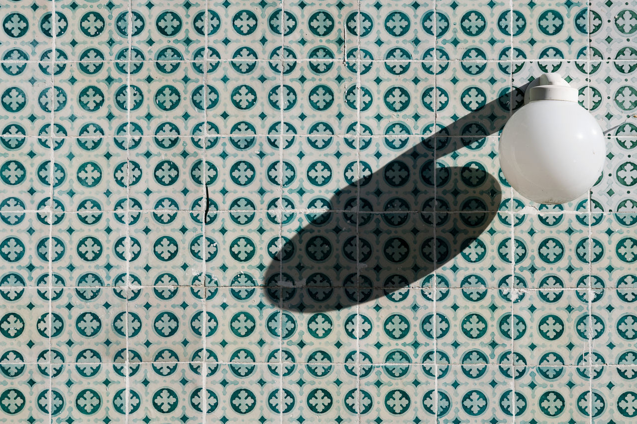 HIGH ANGLE VIEW OF ELECTRIC LAMP ON TABLE AGAINST BLUE BACKGROUND