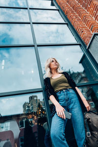 Low angle view of woman standing against window