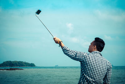 Man taking selfie from mobile phone by sea