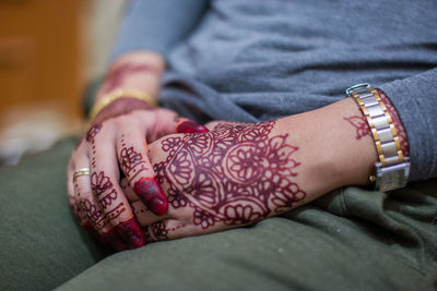 Midsection of woman with henna tattoo