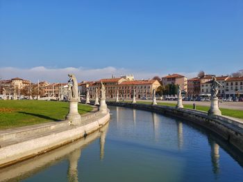 Arch bridge over river against buildings in city