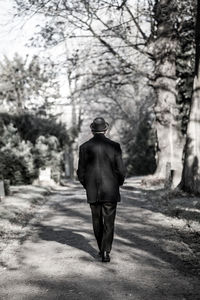 Rear view of man walking on road