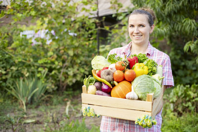 Portrait of young woman picking fruits