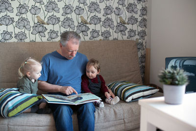 Friends sitting on sofa at home