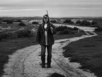 Full length portrait of young man standing on field