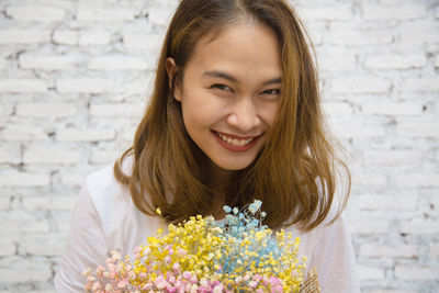 Portrait of smiling woman holding bouquet