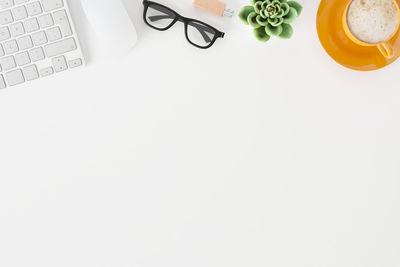 High angle view of eyeglasses on table against white background