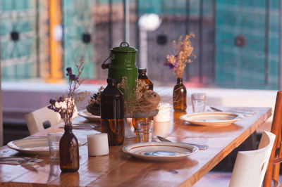 Plates arranged on dining table by window