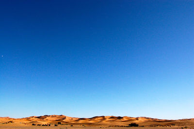 Scenic view of desert against blue sky