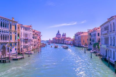 Boats in canal along buildings