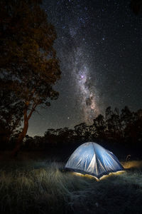 Tent on field against sky at night