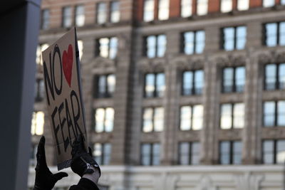 Low angle view of person holding a protest billboard